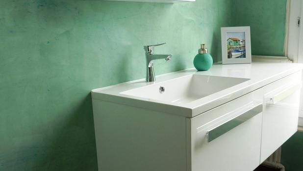 Mur de salle de bain réalisé en enduit décoratif en béton ciré turquoise